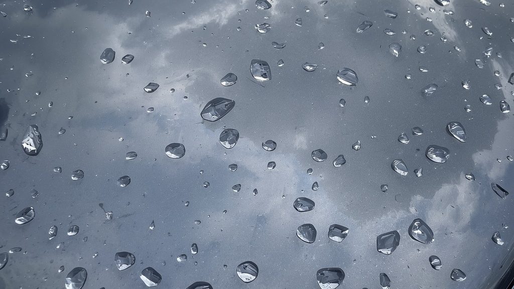 Hail damage repair Broussard Youngsville — car hood covered in hail dents after Louisiana thunderstorm.